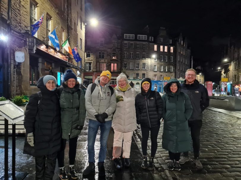 Angus and a group of people standing on a street in Edinburgh at night.