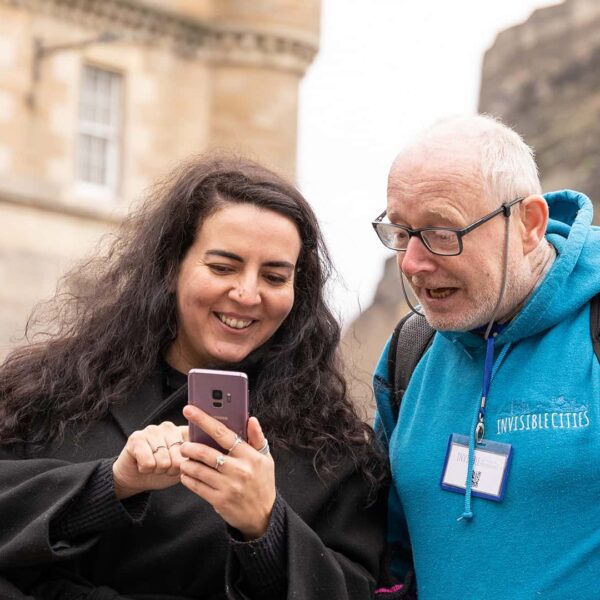 A man and woman looking at a cell phone in edinburgh.