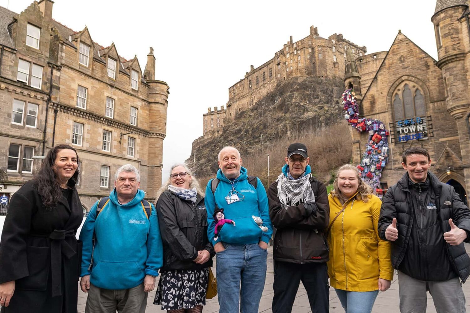 A group of people standing in front of edinburgh castle.