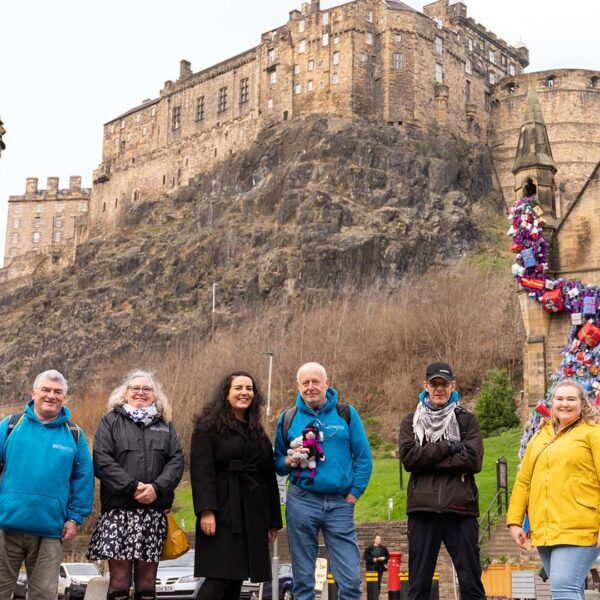 A group of people standing in front of edinburgh castle.