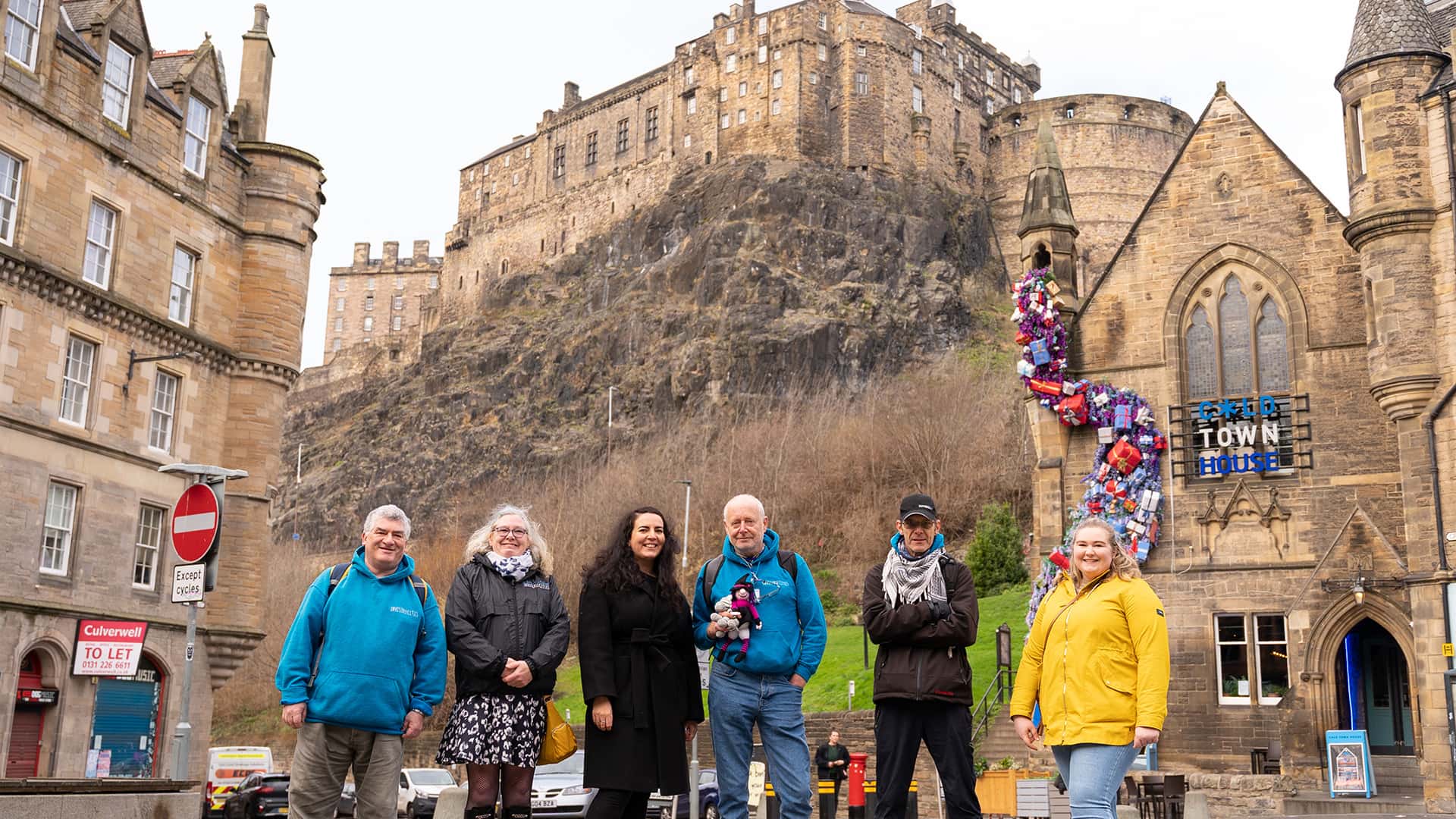 A group of people standing in front of edinburgh castle.