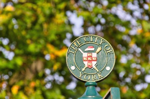A green sign with the words city of York on it, located in the UK.