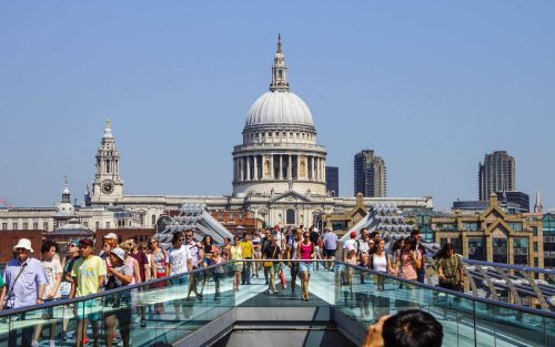 People walking on a glass bridge in London, a bucket list experience in a UK location.